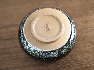 Unglazed base of a Fo Du Jianzhan tea bowl showing the maker's mark, throwing rings, and trimmed foot ring typical of handcrafted Jianyang pottery.