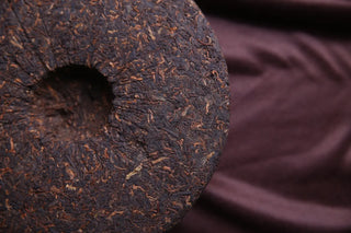 Backside of gongting grade ripe puerh tea cake showcasing the compressed leaf structure and authentic fermentation.