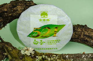 Limited Heritage Edition Shou Mei white tea cake displayed on a natural wood background.