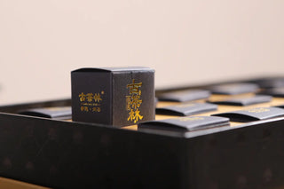 Lincang 2019 Gushu Raw Pu-erh Tea Pearls on a black tray, showcasing the exquisite product detail and packaging.