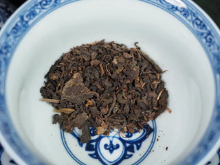 Close-up of loose-leaf Fu brick tea showing "Eurotium Cristatum" (Golden Flower) fungi.