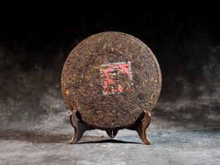 Front view of unwrapped Qilin Hao Fengshan Gushu Ripe Pu-erh Tea Cake 2021, showing round and compact tea cake
