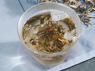 Steeping Yunnan yellow tea leaves in water, illustrating the traditional "smothering" (Men Qing) oxidation process.