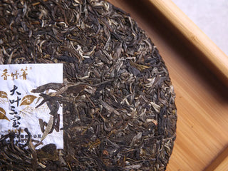 High-resolution close-up showing the tight compression and rich leaf structure of the raw Pu-erh cake.