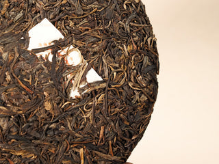 Close-up of the white nei fei inner label pressed into Jing Chang Hao Bada Ancient Trees 2013 raw Pu-erh cake