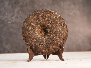 Back unwrapped view of 2019 Qilin Tribute Sheng Pu-erh Tea Cake – Ancient Arbor 357g, highlighting the smooth pressed surface of the tea cake.