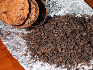 High-quality Menghai ripe Pu-erh tea leaves blended with aged Xinhui Chenpi pieces on tinfoil.