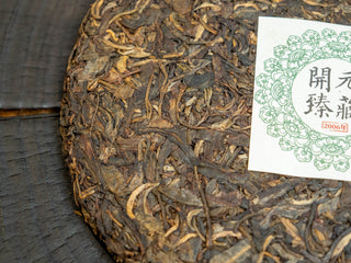 Close-up of 2006 raw Pu-erh tea cake surface texture with embedded inner trademark silk (Neifei).
