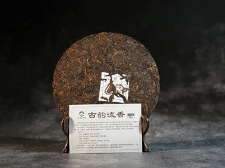 Bulang Mountain Ancient Tree Ripe Pu-erh tea cake fully unwrapped alongside product card, showing full tea cake presentation