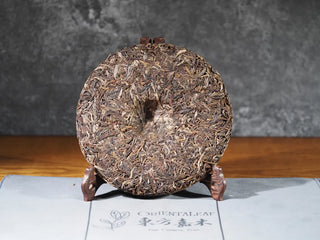 Back view of 2018 Dazhai Ancient Tree Raw Pu-erh Tea Cake without packaging, highlighting tea leaves
