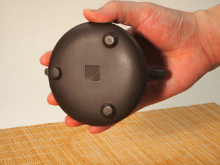 Underside of the Fengming Ziye Shipiao Yixing teapot showing three rounded feet and the square maker's seal stamp