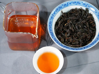Floral Wuyi Rock Oolong – Jin Guanyin (204 Cultivar) tea liquor in pitcher and tasting cup with wet leaves, showing its bright floral and sweet profile.