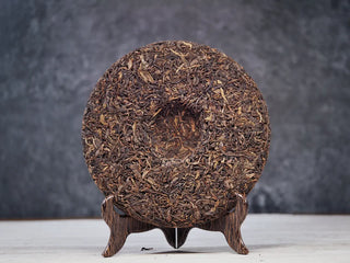 Back side of unwrapped 2019 Lincang Ancient Arbor Sheng Pu-erh Tea Cake highlighting tight leaf compression