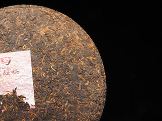 Detailed texture of high-quality fermented tea leaves and golden tips on the surface of 2021 Dayi 7572 ripe puerh cake.
