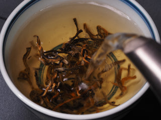 Pouring hot water over deep fermented Crimson Dianhong tea leaves