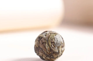 High-quality 2022 Yunnan ancient tree white tea dragon pearl showing silver buds and dried leaves.