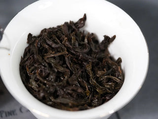 Wet tea leaves (leaf bottom) of Huang Guan Yin 105 after steeping, displaying the "green leaf with red edge" characteristic.