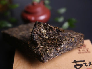 Compressed 2017 Xiangzhuqing Ancient Tree Sheng Pu-erh Brick showing leaf texture and tight compression.