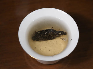 YXT Jingyang Golden Flower Fu Tea Special Grade pieces and traditional butter in a cup, referencing the traditional Tibetan dark tea preparation.