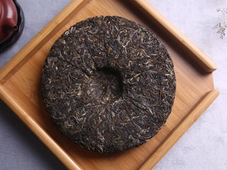 Top-down view of the 357g Three Legendary Leaves Pu-erh Cake, emphasizing color and texture.