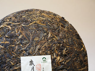 Close-up of the internal ticket (Neifei) embedded in the 2005 Lincang aged Sheng Pu-erh tea cake.