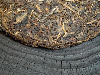 Detailed close-up of the well-preserved edge and thick tea leaf stripes of the 2006 aged Puerh cake.