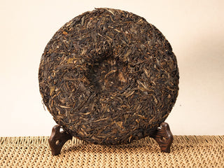 Back of Jing Chang Hao Bada Ancient Trees 2013 raw Pu-erh cake showing the center dimple and loose compressed leaves