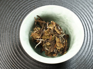 Dry 2021 sun-dried Fuding Shou Mei tea leaves placed in a white ceramic gaiwan before brewing, photographed from above.