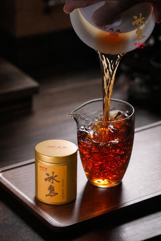 Mengku Rongshi Bingdao Aged Ripe Pu-erh tea poured from a gaiwan into a glass pitcher, liquor a clear deep reddish amber.