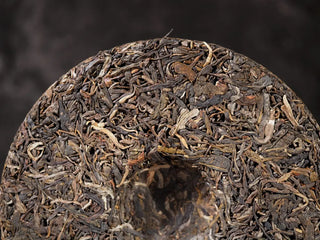 Detailed macro shot of the back of Ancient Arbor Harmony Raw Pu-erh Tea cake showing ancient arbor tea leaf fibers.