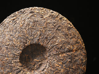 The back side of the 2017 Dayi 7452 ripe puerh tea cake, showing the traditional central compression indentation.