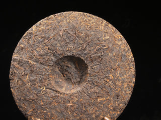 The back side of the 2021 Dayi 7572 ripe puerh tea cake, showing the traditional compression indentation (bowl shape).