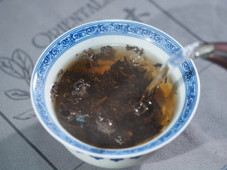 Initial rinse of the 2015 Vintage Fu Brick tea in a blue and white porcelain gaiwan, awakening the aged woody aroma.
