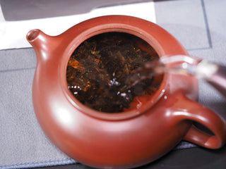 Pouring hot water into an Yixing clay teapot to brew the 2019 Genshe "Datewood Pressed" Fu Brick tea.

