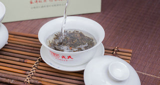 Pouring hot water into a Gaiwan to brew aged Mengku Rongshi raw Puerh tea.