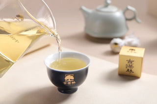 Pouring brewed 2022 Yunnan Shou Mei white tea into a cup showing bright apricot liquor.