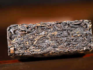 Cross-section view of the fermented 2023 Fengqing Dark Tea brick showing density.