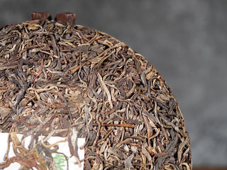 Close-up of front surface of 2018 Dazhai Ancient Tree Raw Pu-erh Tea Cake, showing leaf details