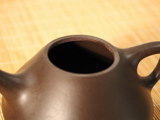 Close-up of the Fengming Ziye Shipiao Yixing teapot rim and opening, showing the dense raw Shihuang clay texture