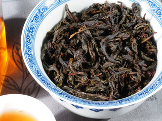 Close-up of the wet leaves of Jin Guanyin (204) Wuyi Rock Oolong, showing thick elastic leaf texture, red edges, and lingering orchid–osmanthus aroma.