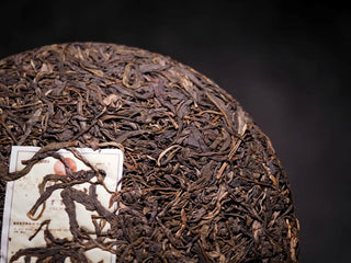 Close-up of the front surface of 2019 Lincang Ancient Arbor Sheng Pu-erh Tea Cake showing rich leaf texture and silvery tips