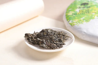 A portion of broken-off Lincang raw pu-erh tea leaves in a ceramic dish, ready for Gongfu brewing.