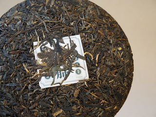 Close-up texture of compressed Mangfei Mountain raw Pu-erh tea leaves