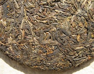 High-resolution close-up of the compressed tea leaves in a 2005 Mengku raw Pu-erh cake.