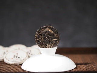 Mengku TeaSoul Sheng Pu-erh Coin Tea unwrapped, revealing compressed 4g coin tea with golden tips