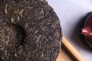 The back center dimple (compression hole) of the 2016 raw puerh cake, showing deep leaf integrity.