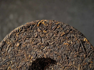 Close-up of the back of Qilin Hao Fengshan Gushu Ripe Pu-erh Tea Cake 2021 showing leaf texture and pressed pattern