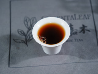 A cup of brewed Vintage Imperial Puerh tea, showing the clean, reddish-brown liquor achieved through dry aging.
