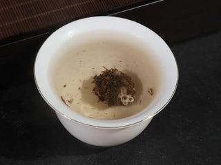 First infusion of 12-year aged Yiwu Raw Puerh tea showing the pearl unfurling.