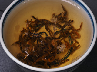 Beautifully steeped golden buds of Crimson Dianhong Black Tea liquor
